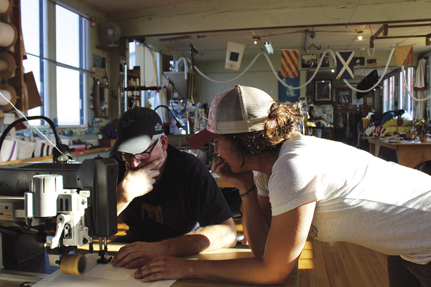 Lacy Capel helps a sailmaking student problem-solve on the sewing machine. 