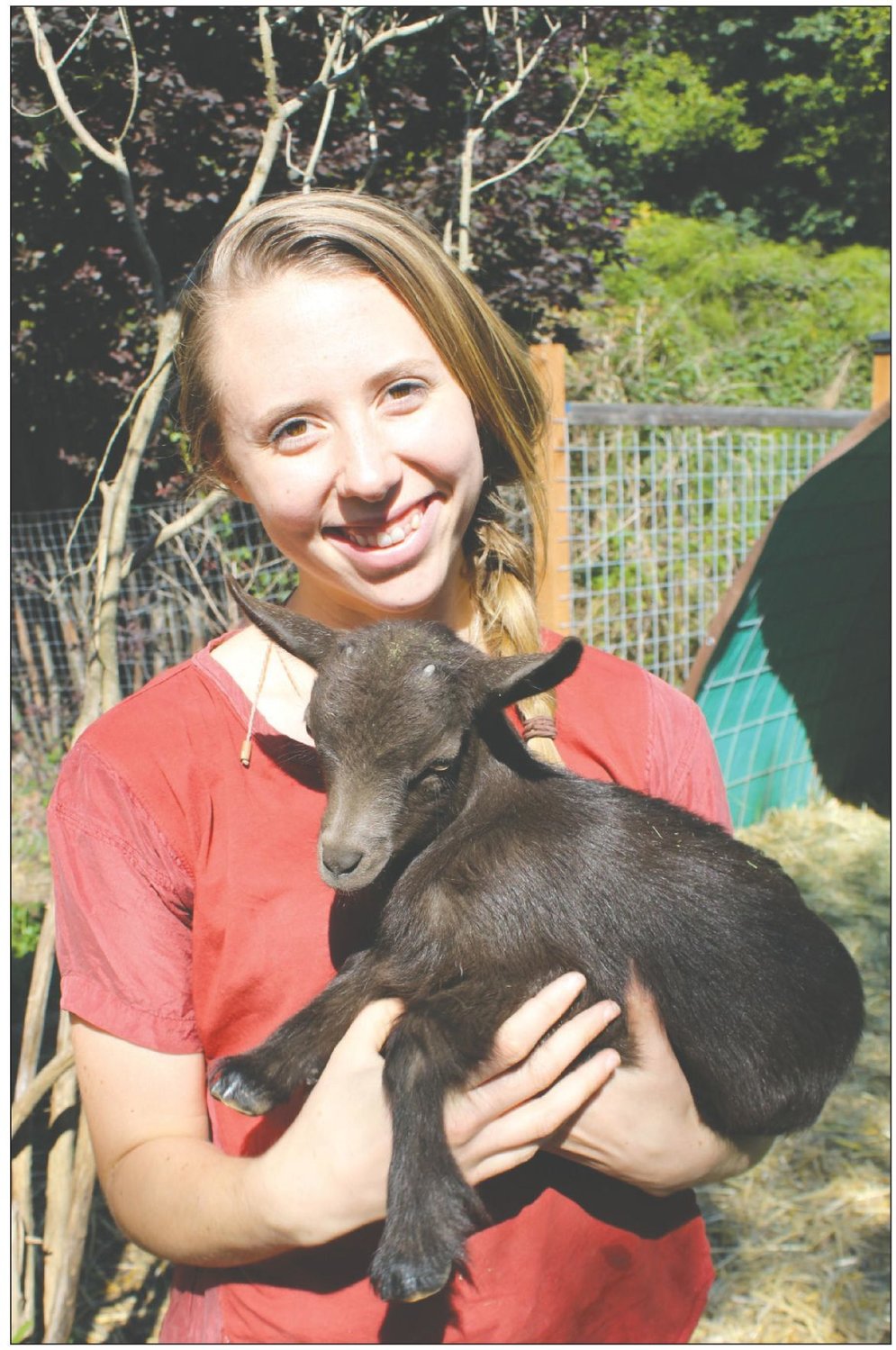 Grace Thompson, co-owner of Kodama Farm &amp; Food Forest holds one of their baby goats they are raising to eventually make goat cheese.