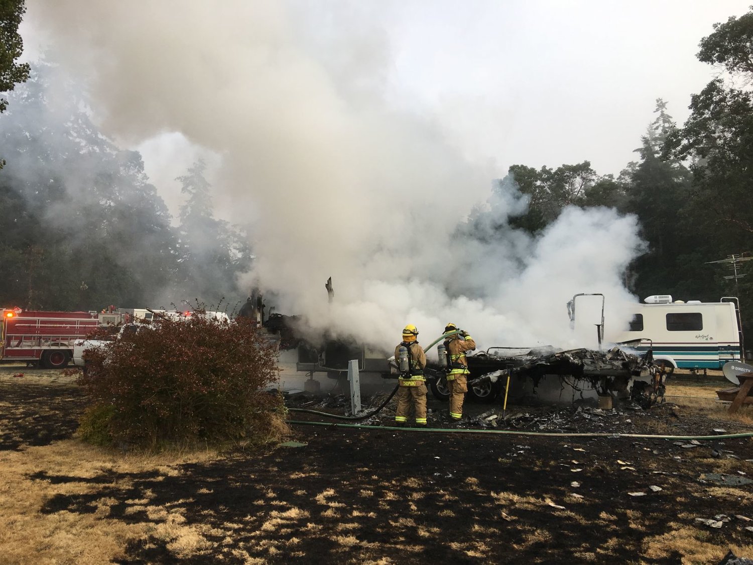 Firefighters survey the aftermath of a fire in the 9000 block of Flagler Road July 28, which claimed at least one life. Photo courtesy of Bill Beezley