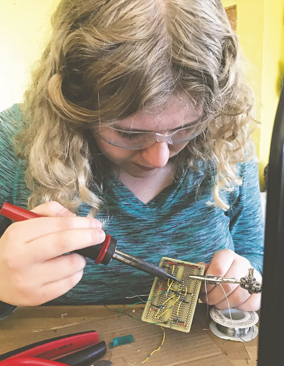 Ella Ashford solders together an asthma early-warning detection device for the Washington State Science and Engineering Fair.