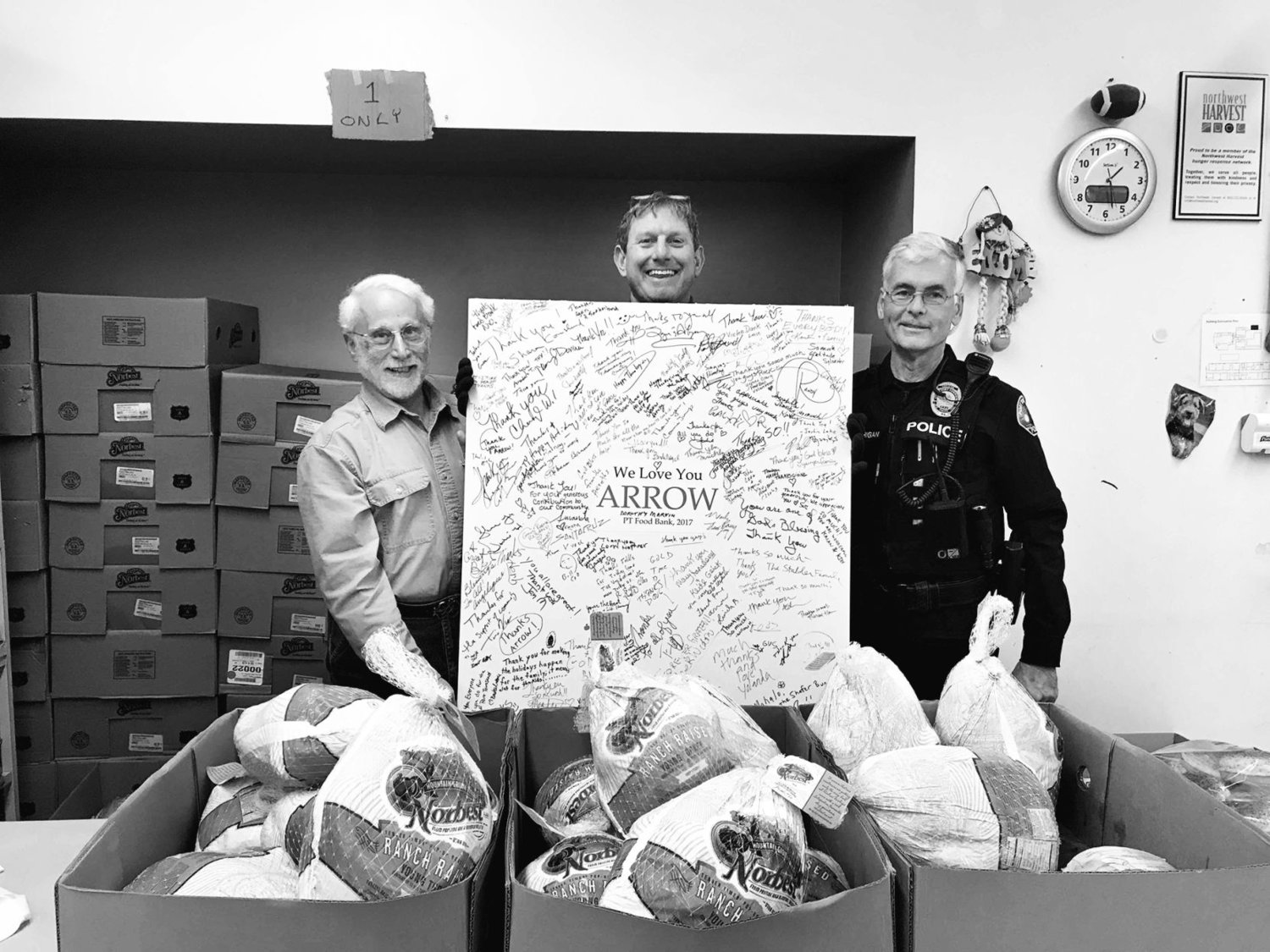 Earll Murman, Arran Stark and Port Townsend police Officer Bill Corrigan stand behind artwork thanking Arrow Lumber for donating turkeys for eight years in a row. Photo courtesy Earll M. Murman
