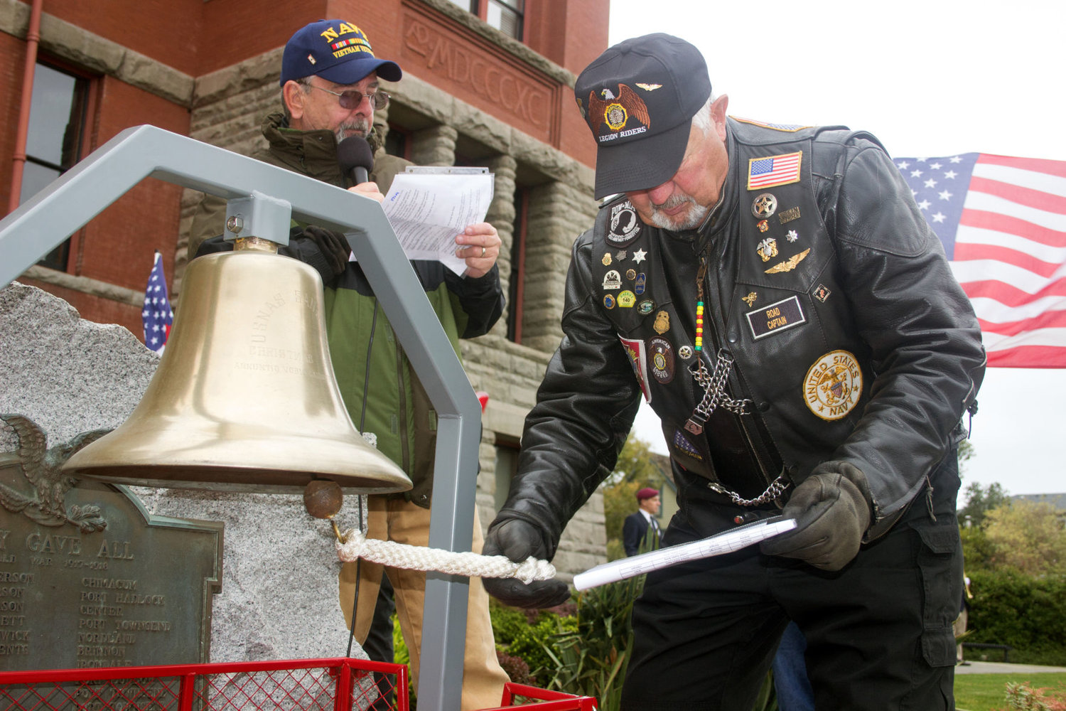 Steve Brunette reads the names of 32 Jefferson County veterans who have died in the past six months, while Gary Velie rings the bell for each name at the Jefferson County Courthouse Oct. 21. Photos by Kirk Boxleitner
