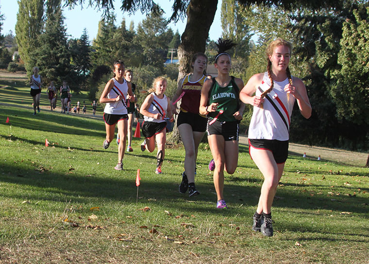 Competing Sept. 28 on Port Townsend's "home" cross-country course are (wearing white) Rachel Matthes (background), Anika Avelino, Ally Bradley and Aliyah Parson. Photo by Patrick Sullivan