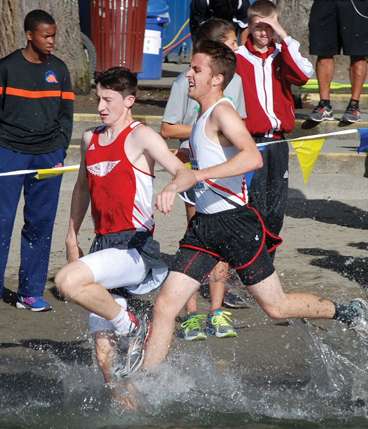 Port Townsend cross-country team senior Brennan LaBrie (right) races Lewi Hagos of King's through the water at the Tahoma Coed Relays at Lake Wilderness State Park in Maple Valley on Sept. 10, 2016. Courtesy photo by Janeen Armstrong