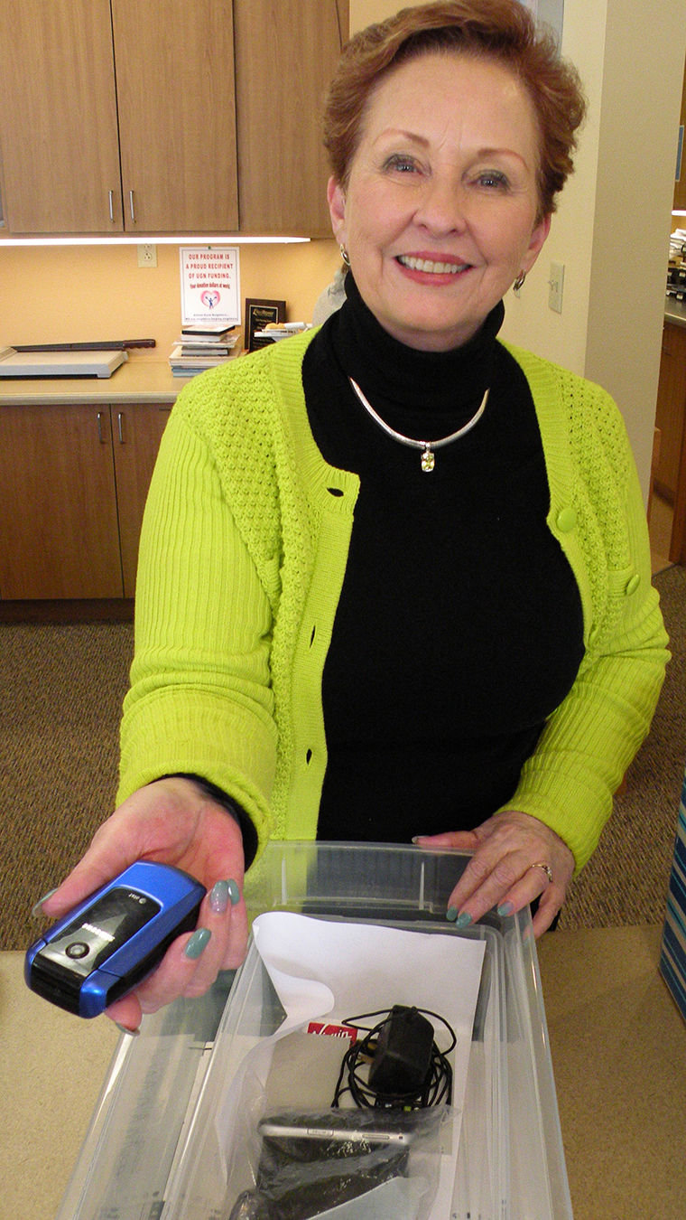Dee Dee Spann, director of programs and services at Dove House Advocacy Services in Port Townsend, accepts a cell phone. The program recycles old cell phones and can exchange them for working cell phones for victims of domestic violence. Photo by Allison Arthur
