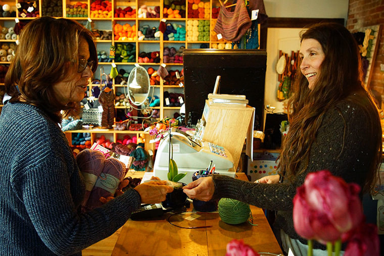 Numahka Swan (right), co-owner of Bazaar Girls Yarn Shop, hands customer Jeannette Ricardo of Port Townsend a receipt of her purchase Monday, April 4 at the downtown Port Townsend store. Photo by Nicholas Johnson