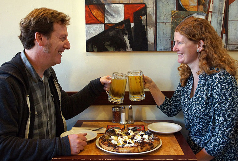 Ned Herbert and Virginia Marston, co-owners of the Pourhouse, chose a classic pairing of pizza and pilsner. Here, they toast with glasses of Chuckanut pilsner while sharing a White Pie at Hillbottom Pie recently in downtown Port Townsend. Read about 12 beer and food pairings starting on page AX of this issue. Photo by Nicholas Johnson