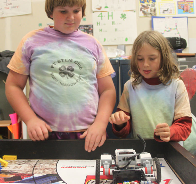 Nathaniel Ashford and Timber Cochran test their robot on the "challenge table" Nov. 6. As members of the 4-H PT STEM Club, they're learning how to design, build and program autonomous robots. Photo by Robin Dudley