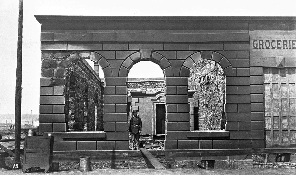 The 1889 Seattle fire demolished Seattle, all wooden banks and their contents. Only Carkeek's stone vault, seen through the doorway, survived.
