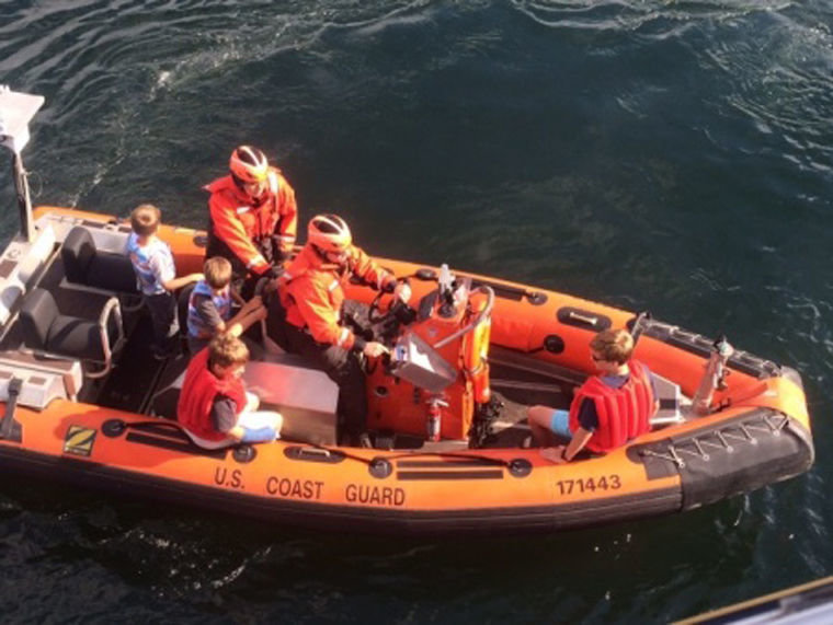 Smallboat crew from the Coast Guard Cutter Sea Fox, an 87-foot patrol boat home-ported in Bangor, removes four children from the 32-foot pleasure craft Kloshie Bay which was reported on fire near Point Wilson, July 27, 2015. U.S. Coast Guard photo courtesy of the Coast Guard Cutter Sea Fox