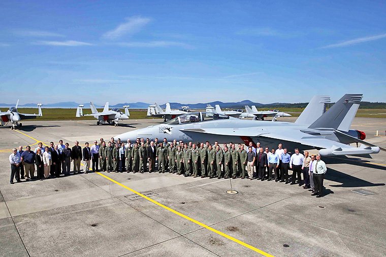Members of the Naval Aviation Requirements Group pose on May 15, 2014 in front of the 100th EA-18G Growler delivered to the U.S. Navy on the tarmac at Naval Air Station Whidbey Island. The Navy is replacing the EA-6B Prowler with the more capable Growler. U.S. Navy photo by Mass Communication Specialist 2nd Class John Hetherington