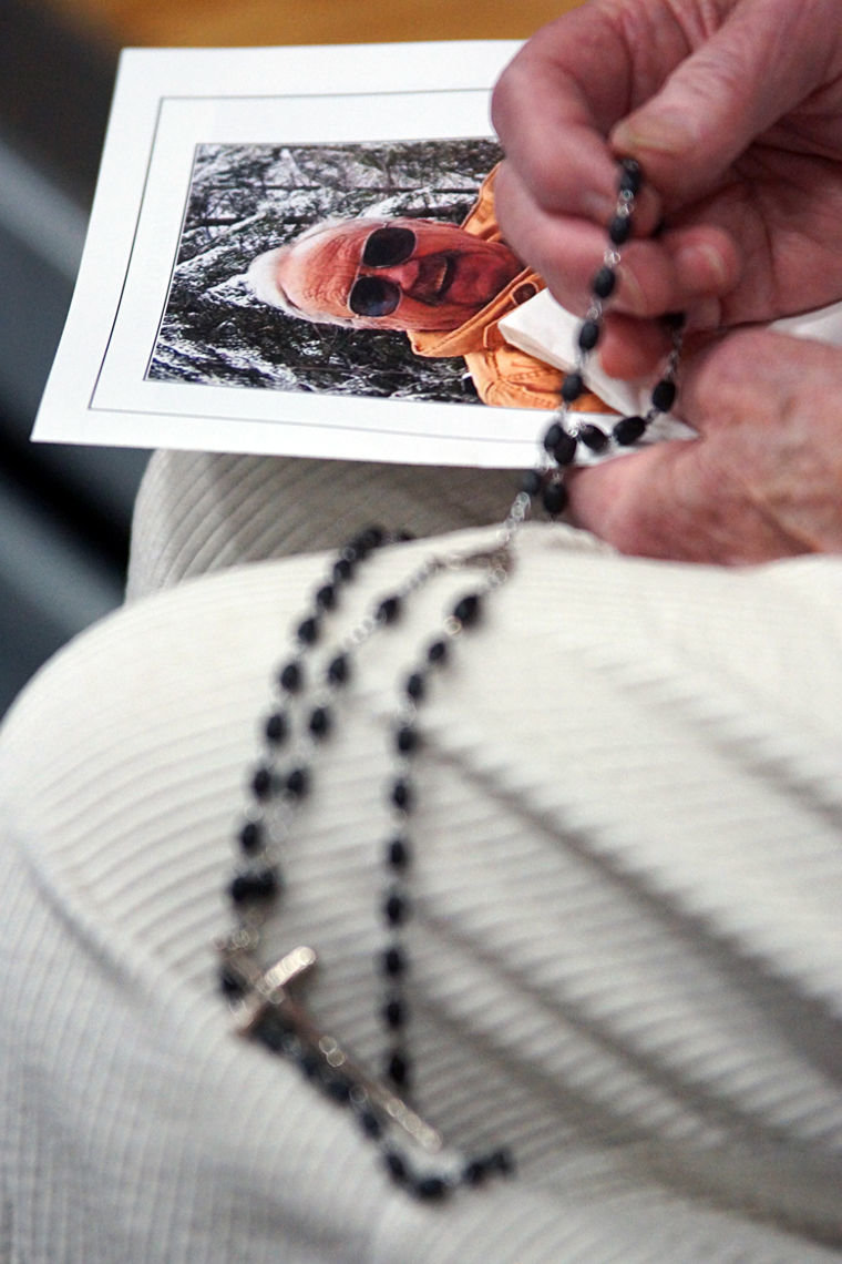 A woman holds her rosary and a copy of a program Saturday, Feb. 21 during a memorial service for Robert “Moe” Moser at Quilcene School. Photo by Nicholas Johnson
