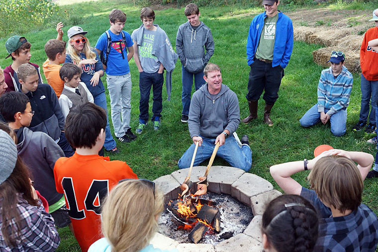 Aaron Stark, executive chef at Jefferson Healthcare, demonstrates a traditional method of roasting salmon over a fire Friday, Oct. 3 at Finnriver Farms with Blue Heron seventh-graders. Photo by Nicholas Johnson