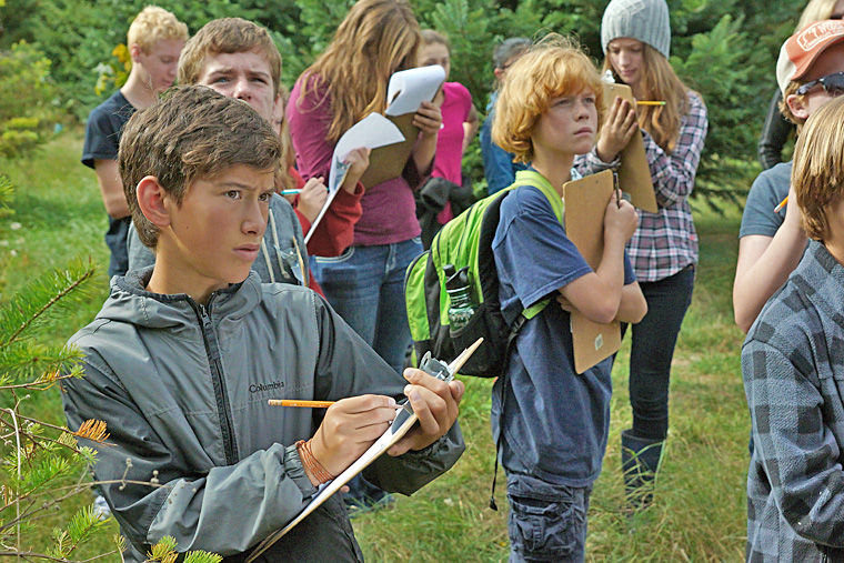 Seventh-grade students from Blue Heron School take notes while walking the land along Chimacum Creek at Finnriver Farm on Friday, Oct. 3. The students observed various types of trees and considered which might best combat reed canarygrass. Photo by Nicholas Johnson