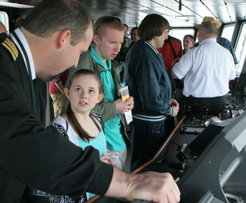 Washington State Ferries Capt. Matt Miller shows Cassie Earl, 14, the Salish pilothouse. Photo by Patrick J. Sullivan