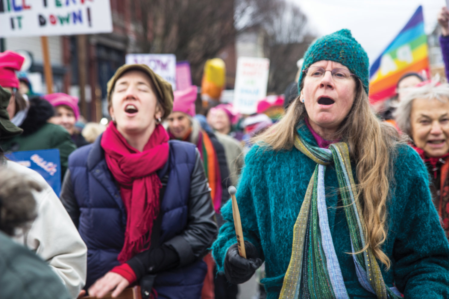 Musicians Aimee Ringle, left, and Gretchen Sleicher lead the crowd in protest songs as they march down Water Street.