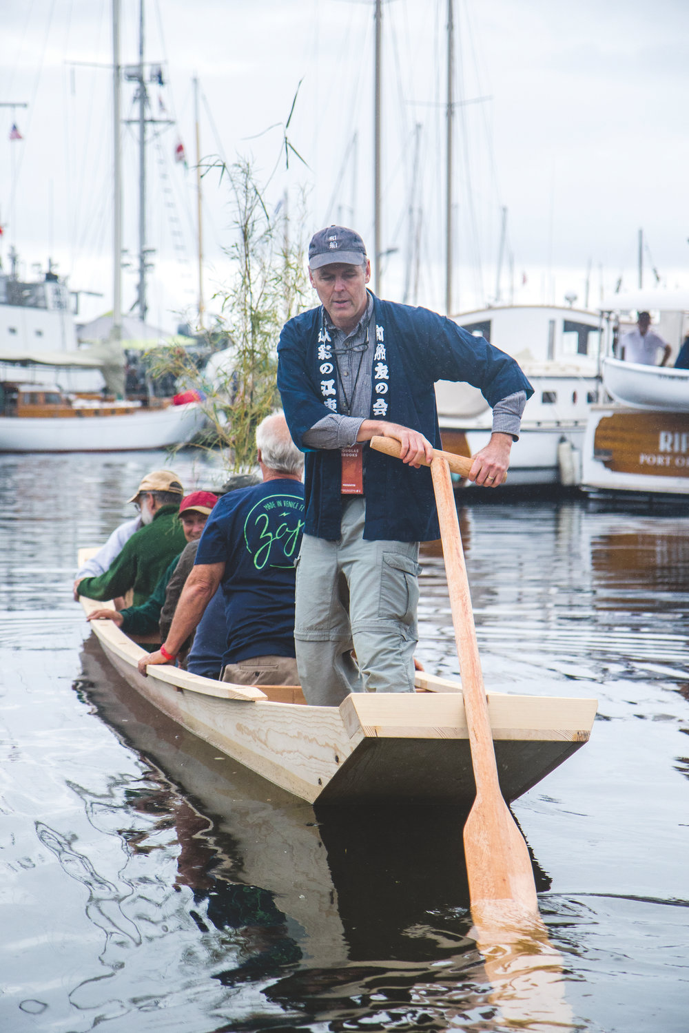 Douglas Brooks uses the sculling oar to launch the Shinano river boat with the boat builders.