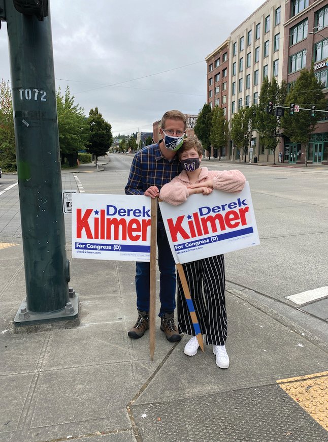 U.S. Rep. Derek Kilmer pauses for a photo with his daughter, Tess, during a day of sign-waving at the corner of South 21st Street and Pacific Avenue in downtown Tacoma.