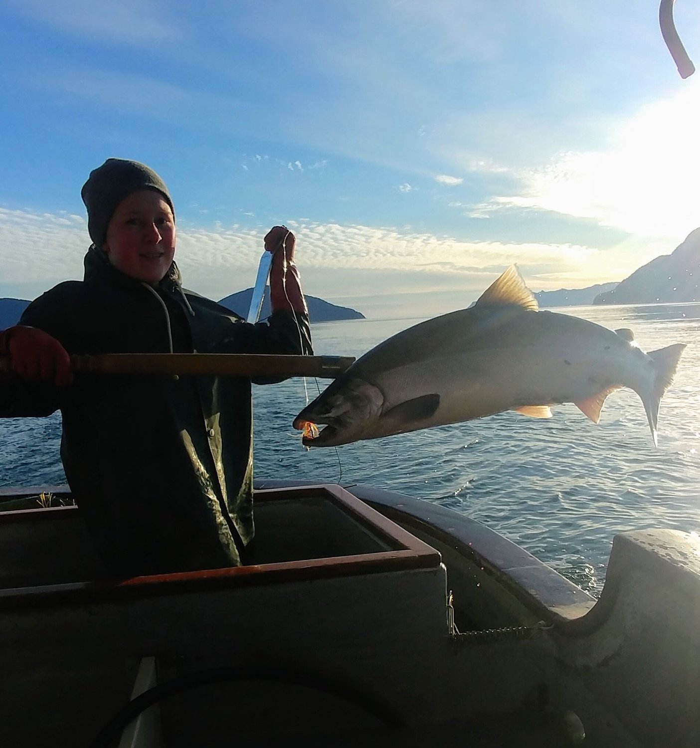 Anabel Moore hauls in a coho salmon aboard the F/V Ocean Belle