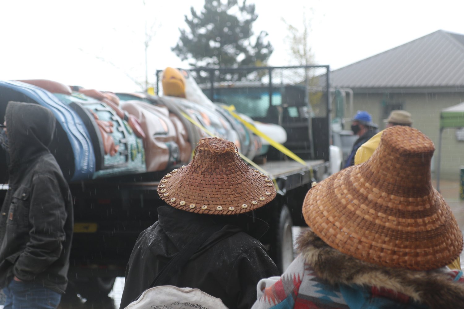Wearing traditional hats made of woven cedar bark Jewell James and Heather Misanes look to the recently-finished totem pole during a blessing ceremony at Pope Marine Park in Port Townsend.