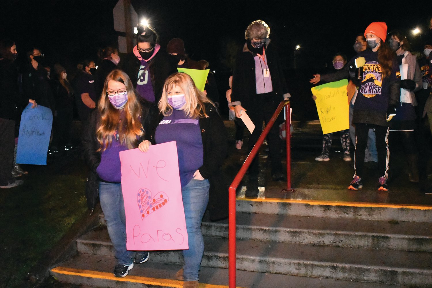 Paraeducators and classified school staff members enter the Port Townsend School district’s front office building to attend the board meeting and give public comments advocating for higher wages.