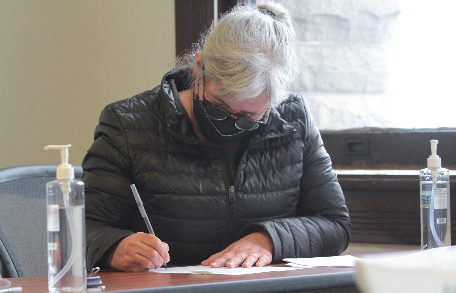 County Commissioner Heidi Eisenhour, as a member of the Jefferson County Canvassing Board, signs paperwork in the county courthouse Friday afternoon to finalize the February 2022 Special Election.
