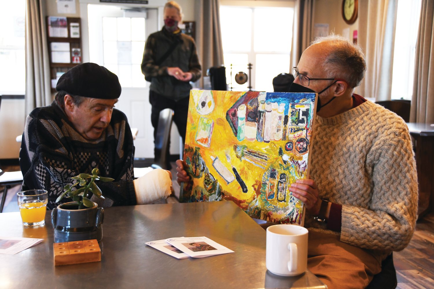 Craig Rogers shares the inspiration behind “The Artist’s Studio” while close friend Robert Komishane holds the piece.