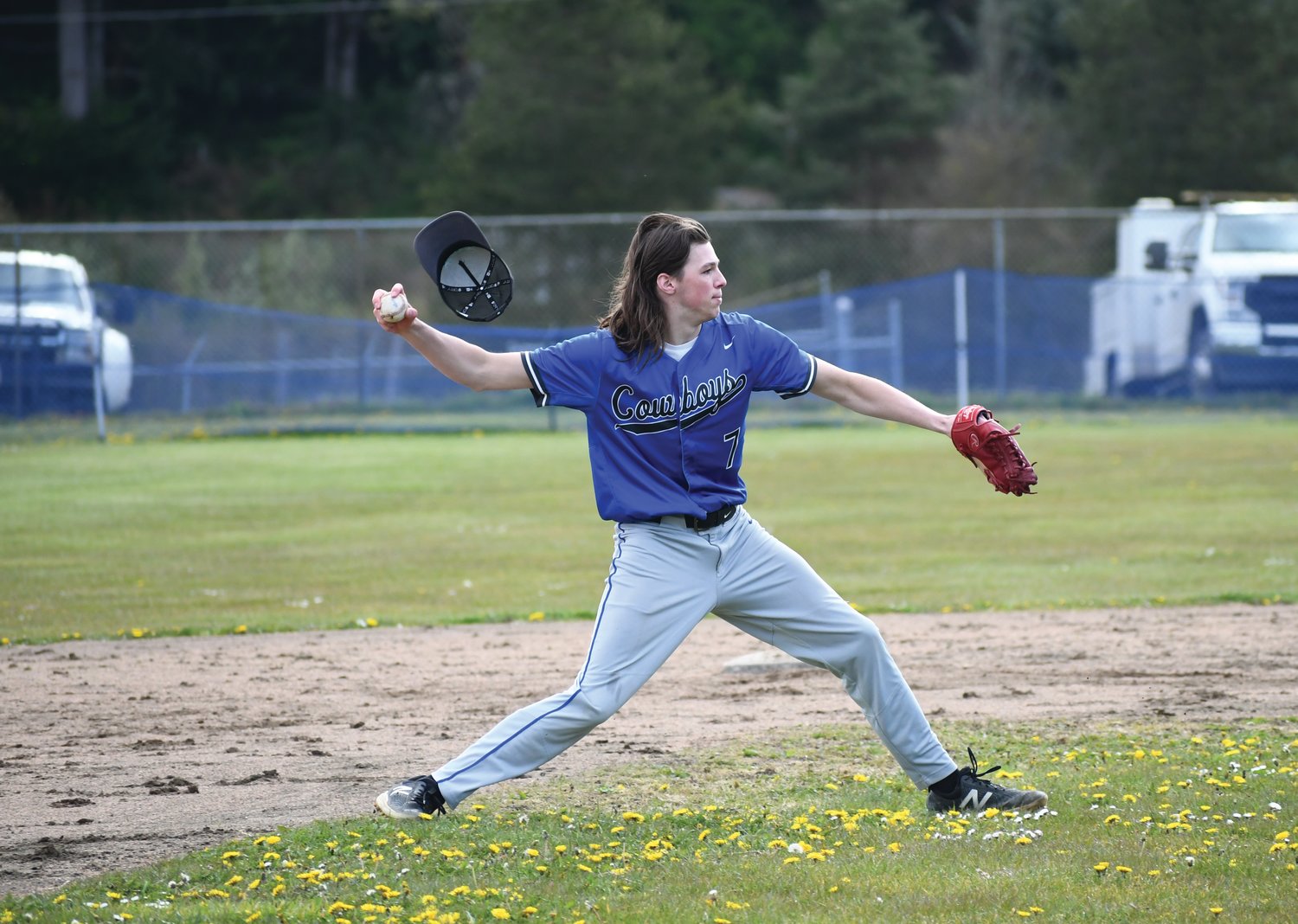 Playing shortstop for the Rivals, Ryan Popp loses his hat while throwing to first base.