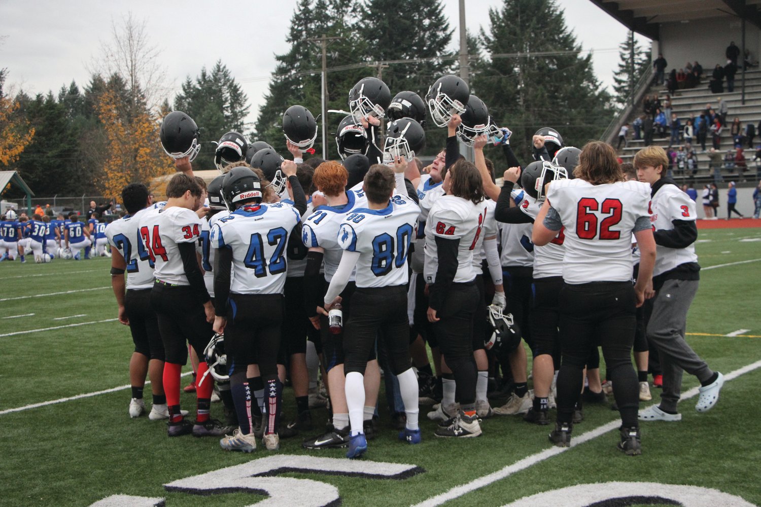 Chimacum and Port Townsend high school players with the East Jefferson Rivals football team huddle up after their playoff loss to Eatonville High in November.
