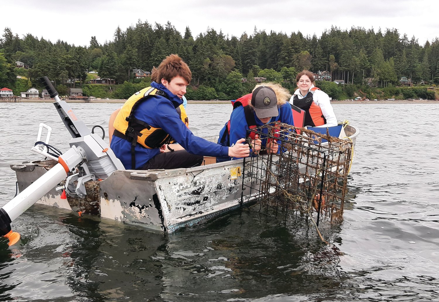 Logan Flanagan and Ella Ashford retrieve a crab pot from the ocean. The team uses GPS data to track down suspected locations of derelict crab traps, or “ghost pots,” around the waters of Port Townsend, then use their ROV to find and recover the traps.