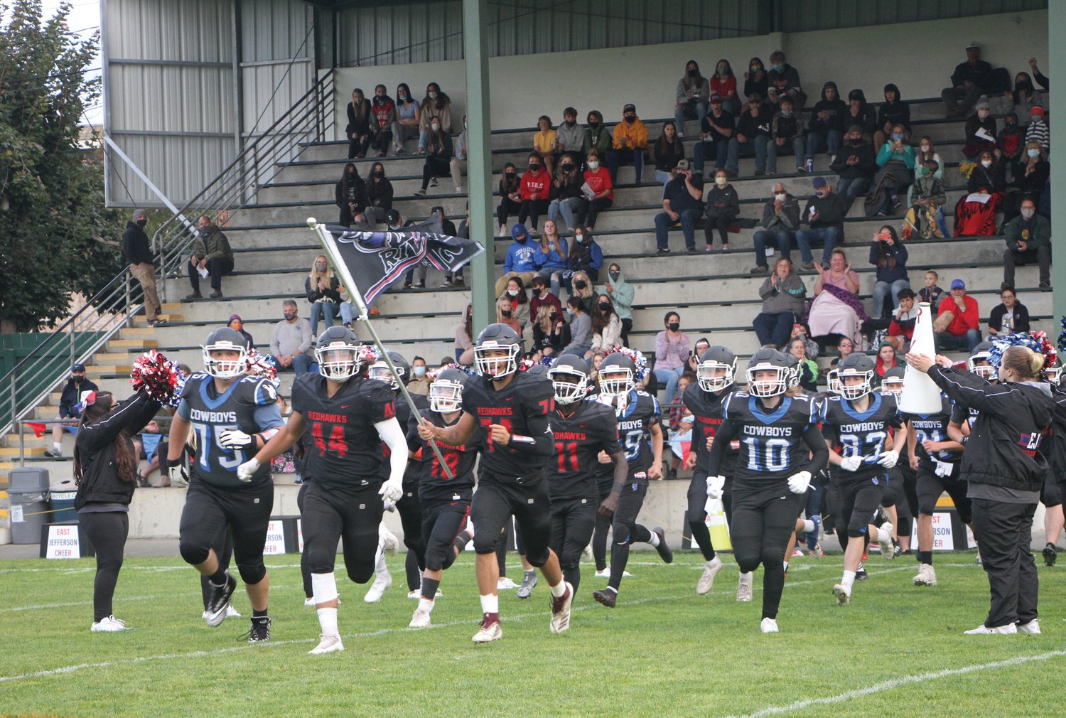 East Jefferson Rivals football players rush onto the field prior to their season opener game versus Granite Falls High School in September 2021.