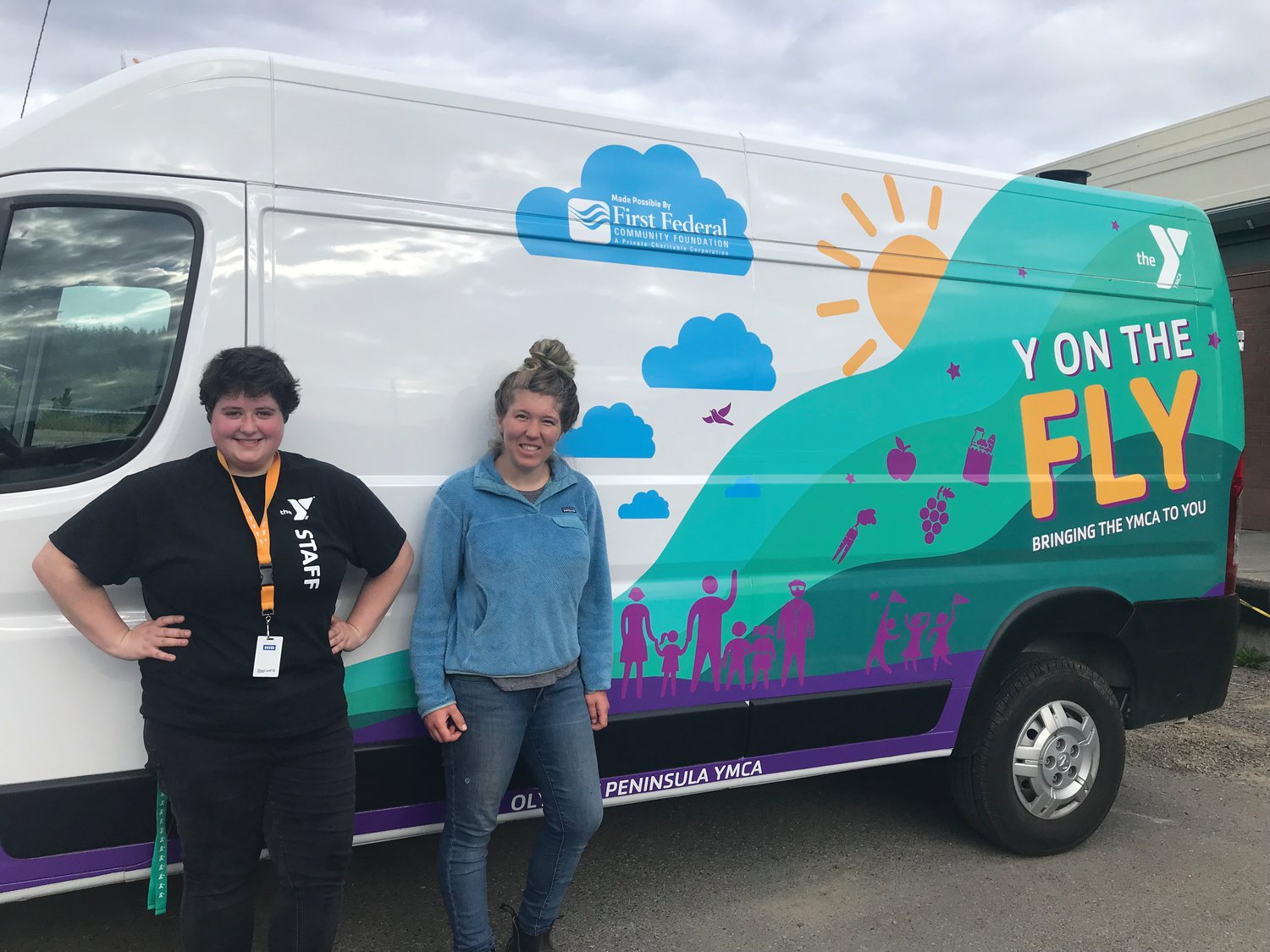 YMCA food security coordinator Sarah Henry and Kenzie Lemay, food security program aide, pose together with the YMCA’s new “Y on the Fly” food delivery van.
