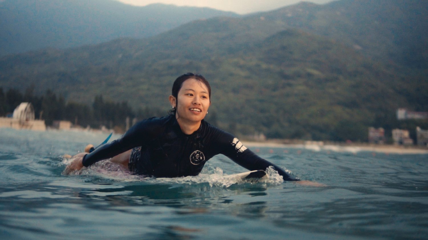 Lolo, one of the central characters of the documentary, rides out to catch a wave in China’s Hainan province, known for its tropical beach environment.