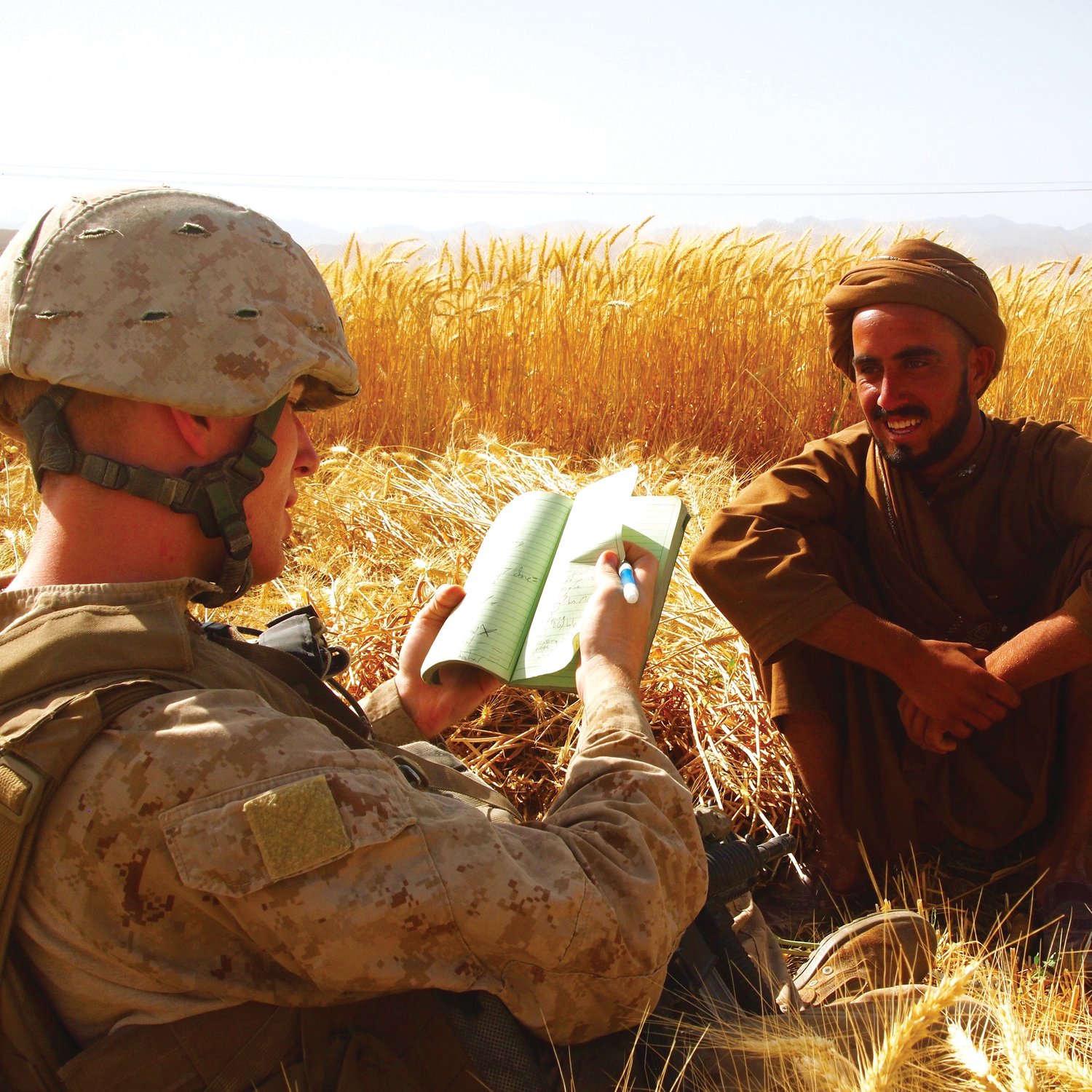 Zaque Harig speaks within an Afghan civilian while on deployment, utilizing his newly-learned knowledge of Pashto (one of the native languages in Afghanistan) to communicate with the man.