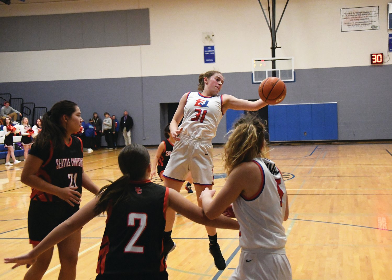 Rivals junior Addy Asbell reaches out to pick up an offensive rebound in the opening half of play.