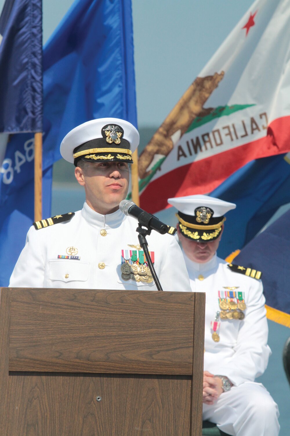 Navy Cmdr. Todd Galvin addresses the crowd at the change-of-command ceremony as Navy Cmdr. Andrew Crouse, background, listens.
