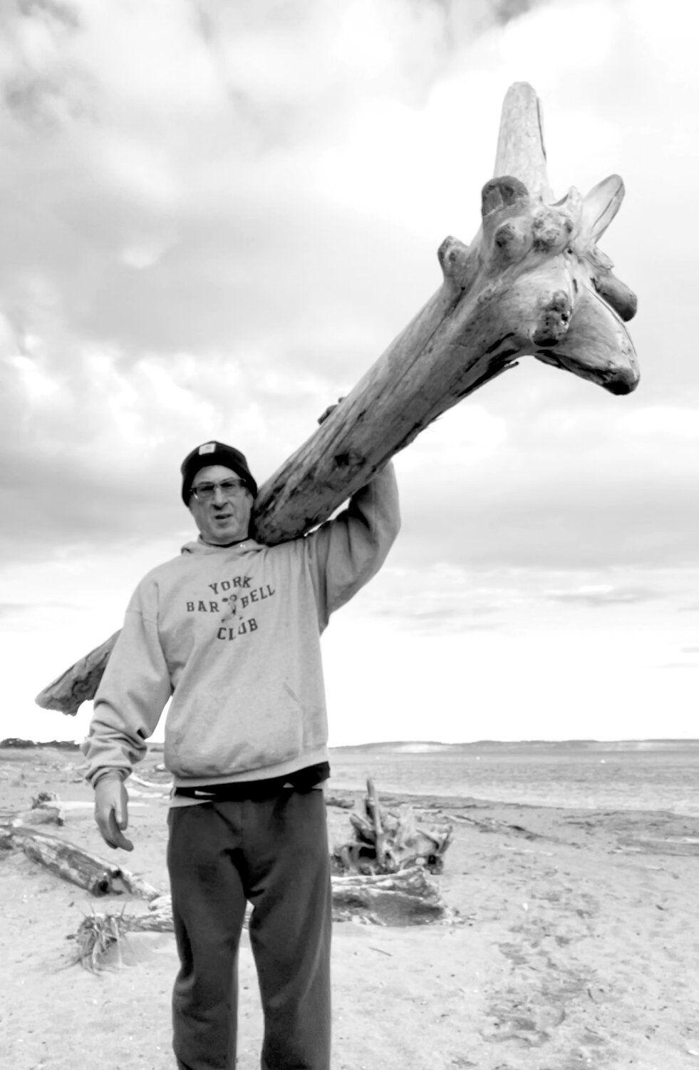 Brooks Kubik, 65, trains for his weightlifting competition by carrying logs down the beach.